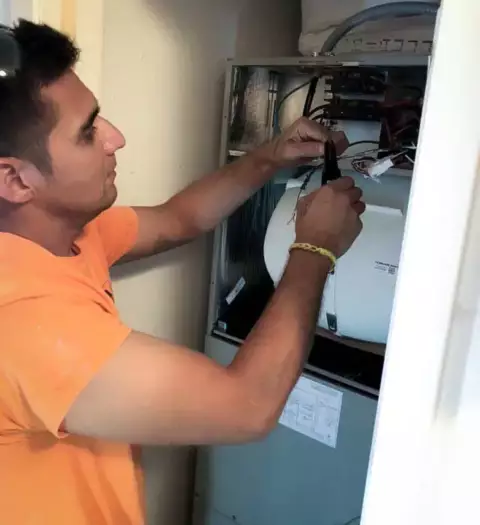 A/C Solutions tech working on an air handler inside a customer's home